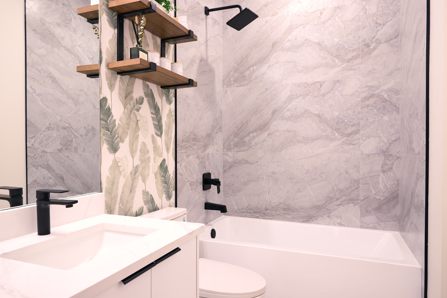 A Zenith ensuite in honed stone, blackened steel fixtures, and oak shelving