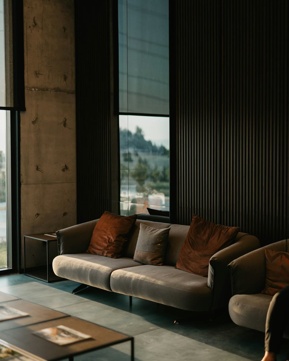 Concrete, dark wood, and textile living space — West Coast interior
